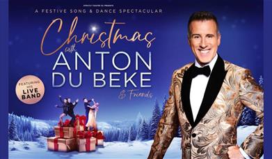 A picture of Anton Du Beke in a snowy night-time landscape, with two pairs of dancers and some Christmas gifts in the background