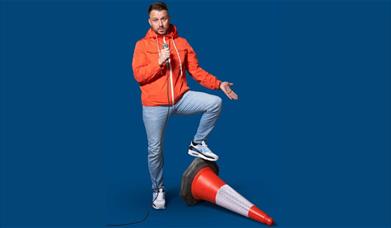 A picture of comedian Daniel O'Reilly, with one foot on a knocked down traffic cone
