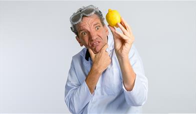 A picture of comedian Henning Wehn, holding a lemon