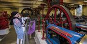People looking at Victorian mill machinery