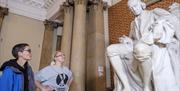 People looking at a large statue of a man