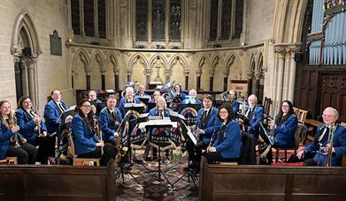 Bradford Concert Band performing with woodwind, brass, and percussion instruments.